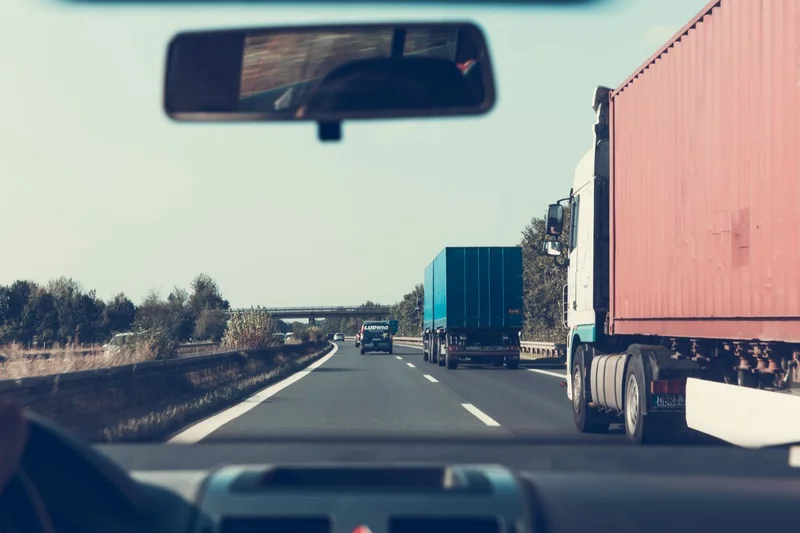 Awaria ciężarówki w Niemczech – praktyczne zwroty 2 Widok z kabiny ciężarówki na kolumnę tirów jadących niemiecką autostradą w ciągu dnia