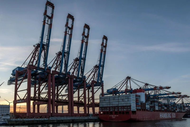 Berlin, Hamburg czy Hanower – gdzie łatwiej zorganizować pracę kierowcy? 1 Terminal kontenerowy w porcie w Hamburgu z dźwigami portowymi o zachodzie słońca