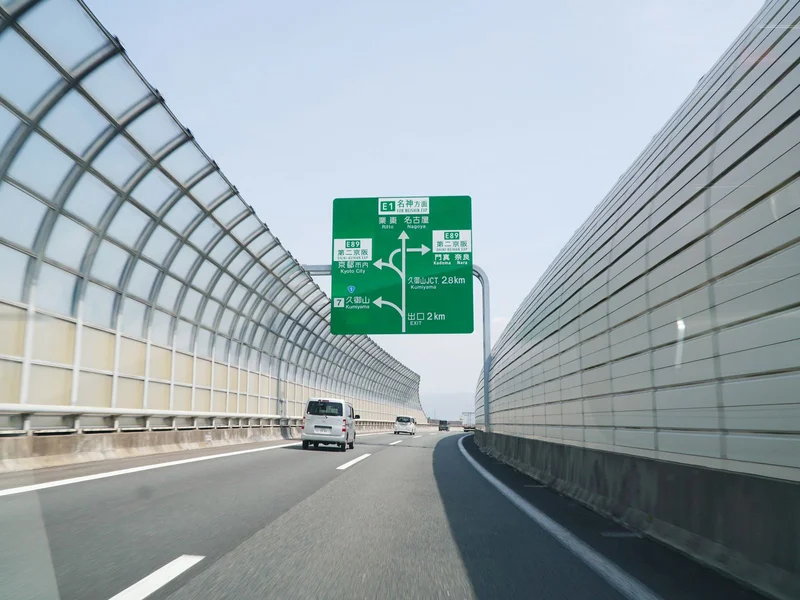Jak wybrać miejsce pracy w Niemczech pod kątem dojazdu z Polski? 2 Zielony znak drogowy z kierunkiem jazdy nad autostradą prowadzącą do miejsca pracy
