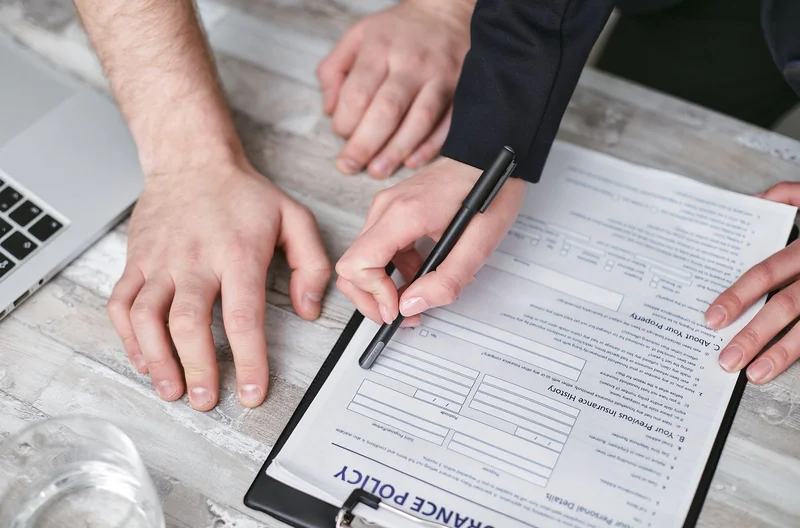 Kolizja ciężarówką w Niemczech – praktyczna checklista kierowcy 2 Dwie osoby podpisują europejski formularz wypadku i dokumenty ubezpieczeniowe