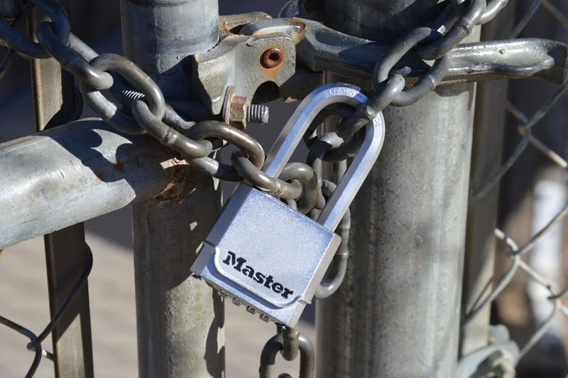 Kradzieże na parkingach ciężarowych – jak ograniczyć ryzyko? 1 Kłódka i łańcuch zabezpieczające bramę wjazdową na parking ciężarowy przed kradzieżą