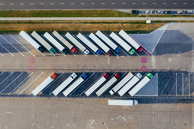 Odpoczynek tygodniowy kierowcy – najczęstsze nieporozumienia 1 Rząd zaparkowanych ciężarówek na parkingu logistycznym podczas przerwy w trasie kierowcy