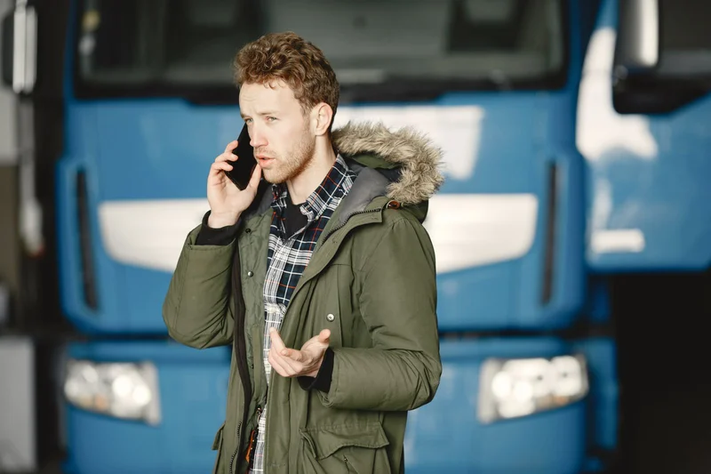 Jak zmienić specjalizację kierowcy i zdobyć doświadczenie na nowym zestawie? 2 Kierowca ciężarówki rozmawiający przez telefon z pracodawcą w sprawie nowej specjalizacji